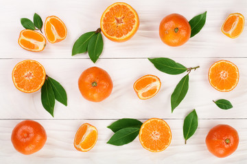 Fototapeta na wymiar orange or tangerine with leaves on white wooden background. Flat lay, top view. Fruit composition