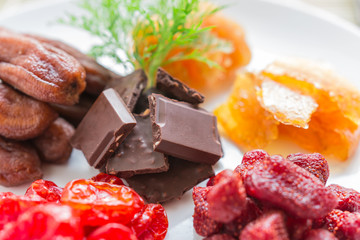 Mixed dried fruits with chocolate in round shape, dried tomatoes, pineapple preserves, strawberries, preserved mango sheet and dried banana, health food concept, Closeup