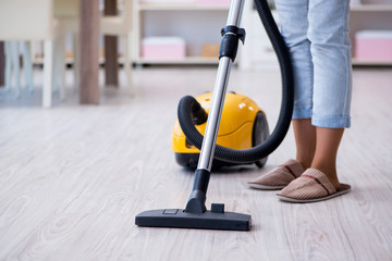 Woman doing cleaning at home with vacuum cleaner