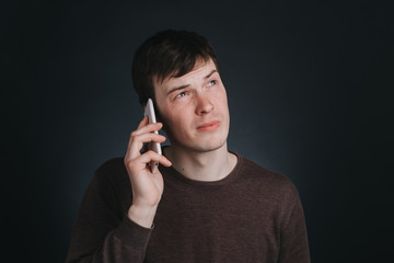 Man talking on the phone, closeup portrait in Studio with a dark background
