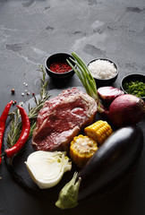 Rib eye steak and vegetables on plate at black background