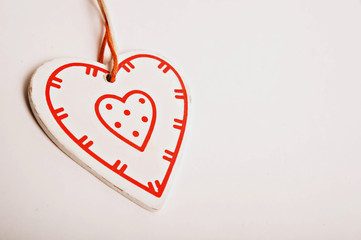 Red wooden heart shaped tag with rope isolated on white