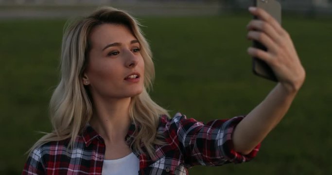 Girl make a self portrait with smart phone. Closeup portrait of carefree blond girl making faces and smiling for felfies