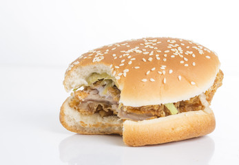 Tasty hamburger missing a bite on a white background.