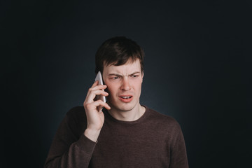 Man talking on the phone heard the shocking news, closeup portrait