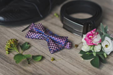 Belt, tie, shoes and a boutonniere on the table 9646.