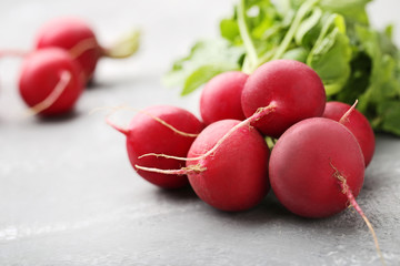 Red radishes on grey wooden table