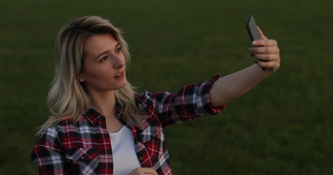 Girl make a self portrait with smart phone. Closeup portrait of carefree blond girl making faces and smiling for felfies