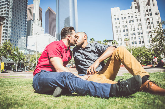 Happy gay couple lying down on the grass