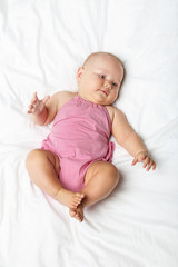 Little newborn baby on white bed