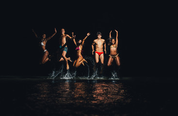 Group of friends taking night bath in the ocean