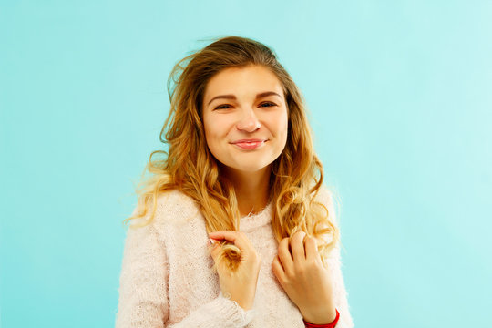 Young happy woman in warm sweater over blue background
