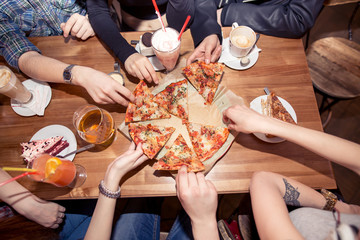 People Hands Taking Slices Of Pizza Margherita. Pizza Margarita and Hands close up over black...