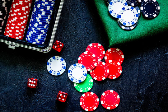 Poker set in a metallic case and green gambling cloth on a grey 