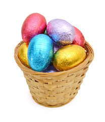 Chocolate easter eggs in basket on white background