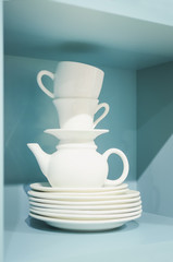 Empty empty dishes are on the table. White tea cups and a teapot. Vertical photography.