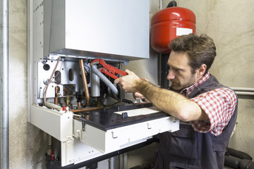 plumber repairing a condensing boiler
