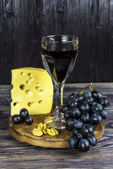 Glass of red wine with fruits, cheese, honey and walnut