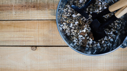 Garden tool in pot on wood background