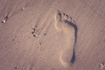 Fototapeta na wymiar Top view of footprints on sand beach in summer vacation seasonal in vintage style. (Selective focus)