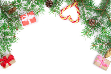 Fototapeta na wymiar Christmas Frame of Fir tree branch with candy canes and boxes isolated on white background with copy space for your text