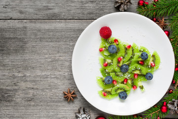 kiwi christmas tree with berries, pomegranate seeds and coconut looks like snow. funny food idea...