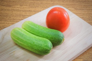 Fresh Tomato with Cucumbers on Cutting Board