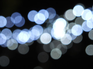 round white and blue bright blurred festive lights against a dark night background