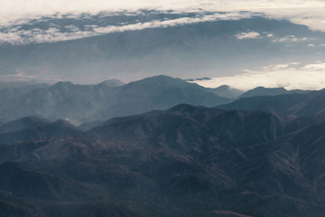 Fototapeta na wymiar aerial shot from plane flying above the california mountains in daytime