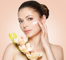 Beauty face of woman with cosmetic cream on face