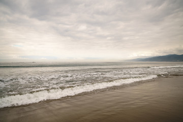 Fototapeta premium ocean waves on Santa Monica beach in cloudy november day