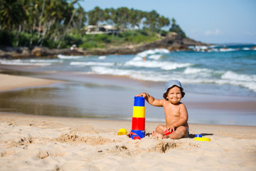 Kid plays with toys at the seashore in summertime