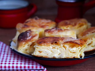 Homemade cheese strudel on plate. Traditional Croatian snack called Masnica, sweet or salty.