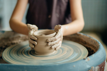 Hands of young potter, close up hands made cup on pottery wheel - obrazy, fototapety, plakaty