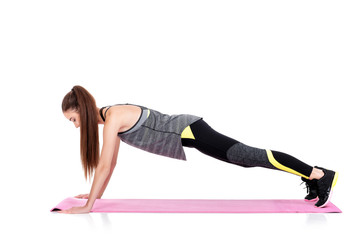 woman in sportswear does exercises on fitness Mat