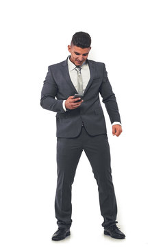 A handsome businessman in an elegant suit with a mobile phone in his hand.
