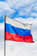 Flag of the Russian Federation fluttering in the wind a background of blue sky and clouds