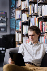 A young man looks into an electronic tablet