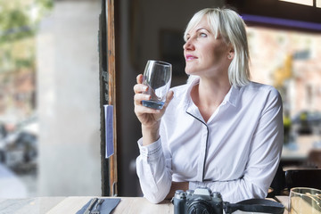 Young woman drinking water in a cafe