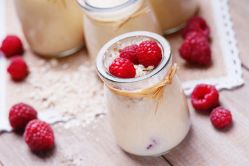 Jars with yogurt, raspberries and oat flakes 