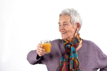 senior woman drinking juice on white background