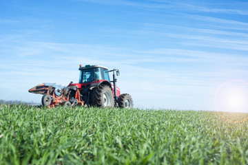 Tractor machine working in the field plowing land. Agriculture and nature.