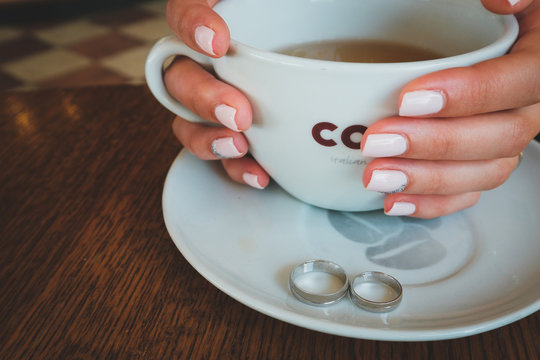 Gold and silver wedding rings in a tea cup