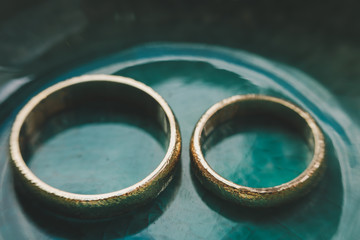 Gold and silver wedding rings in green