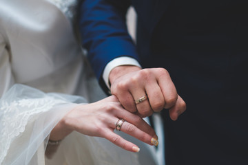Gold and silver wedding rings on couple;s hands