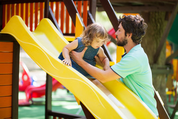 Little kid on playground, children's slide.