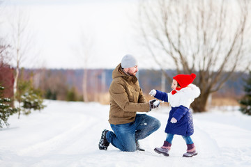 Father and daughter at snowy park.