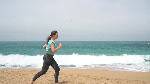 Athletic woman running along the beach