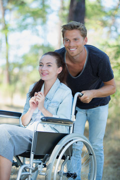 peaceful young couple in wheelchairs in park