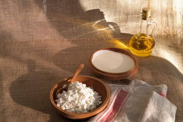 cottage curd and sour cream in wooden plate on a linen tablecloth and place for text